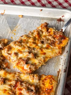 two slices of pizza sitting on top of a pan covered in cheese and meat toppings