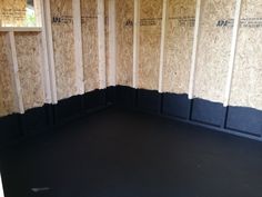 the inside of a room that is being constructed with plywood boards and black flooring