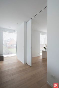 an empty room with white walls and wooden floors