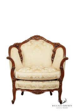 an ornate wooden chair with white upholstered fabric