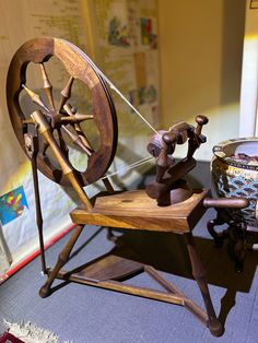 an old spinning wheel on a wooden chair