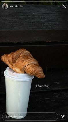 there is a croissant sitting on top of a cup that has been placed in it