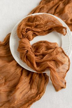 a white plate topped with a brown scarf