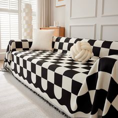 a black and white checkered couch with two pillows on it's back end