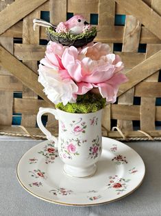 a teacup with flowers in it sitting on a saucer