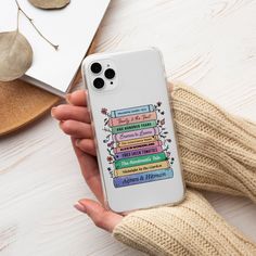 a person holding an iphone case with books on it