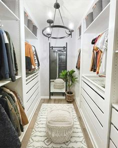 a walk in closet with white cabinets and drawers