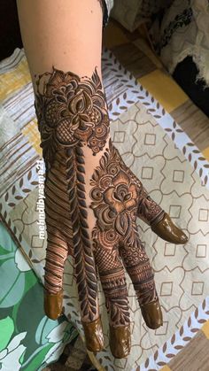 a woman's hand with henna tattoos on it