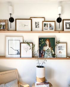 the shelves are filled with pictures and framed art on them, along with plants in a vase