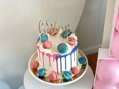 a white cake with blue, red and pink icing on it's side