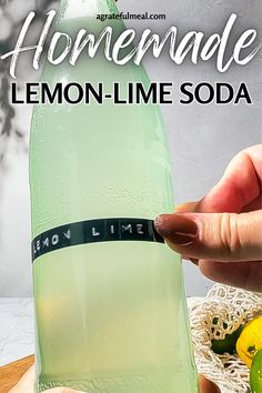 someone is holding a lemon lime soda in front of a bottle with the words homemade lemon - lime soda on it