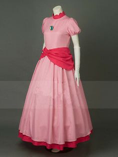 a pink and red dress on display in front of a gray background with white mannequin