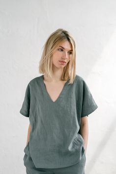 "When ordering you can choose to have the \"SHORTS\" or \"TOP\" only or the whole \"PAJAMA SET\" of both items. When buying a set you save 5 euro. ELLA shorts with elastic waistband and fabric strap. Drop shoulder ELSA v neck top in greenish grey. TOP: - length is ± 62 cm (24.5\") (depends on size) - v neck - loose fit BOTTOM: - outseam ± 38 cm (14.9\") (depends on size) - inseam is ± 10 cm (3.9\") - elastic waistband with fabric strap - two side pockets DETAILS: - 100 % European, pre-washed med Woman Pjs, Linen Pajama Set, Linen Nightgown, Linen Sleepwear, Greenish Grey, Linen Shorts Women, Pockets Details, Linen Pajamas, Fabric Strap