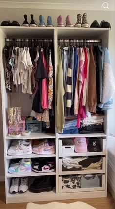 a white closet filled with lots of clothes and shoes