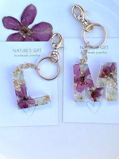 two key chains with flowers on them sitting next to each other in front of a card