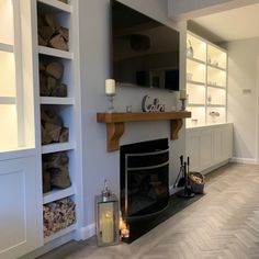 a living room filled with furniture and a fire place next to a wall mounted tv