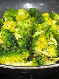 broccoli is being cooked in a pan on the stove