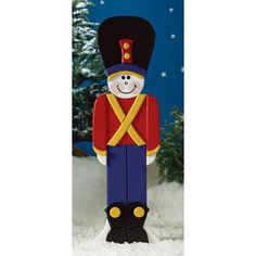 an inflatable nutcracker is standing in the snow with a christmas tree behind it