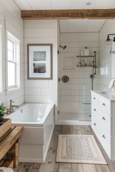 a bathroom with white walls and wood flooring, along with a bathtub in the corner