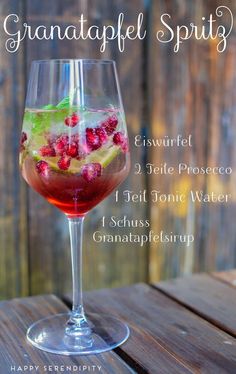 a glass filled with liquid sitting on top of a wooden table