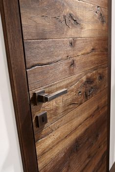 a close up of a wooden door with metal handles