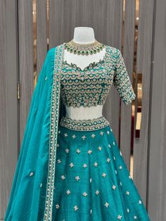 Teal green lehenga beautified in flora gold zari embroidery with sequin, aari tari, cut dana and pearl work all over. Completed look with similarly embroidered cut work blouse with lace border work dupatta. Embrace the whims of rich heritage by adorning this Teal green lehenga. Fabric: Raw Silk Size: 38/M Occasion: Wedding Ceremony or Reception WASH CARE INSTRUCTIONS - Please Dry clean only when it is applicable. Slight color variation is possible due to digital photography. Ready to Ship! Teal Green Lehenga, Cut Work Blouse, Pearl Work, Lehenga Fabric, Zari Embroidery, Green Lehenga, Lace Border, Cut Work, Work Blouse