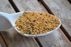 a spoon filled with food sitting on top of a wooden table