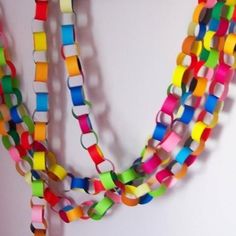 multicolored paper beads are hanging on the wall