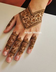 a woman's hand with henna tattoos on it