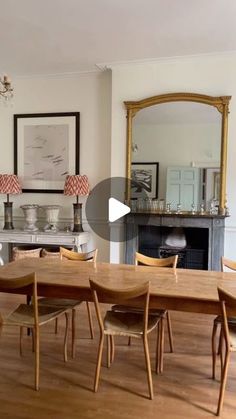 a dining room table and chairs in front of a fire place with a mirror on the wall