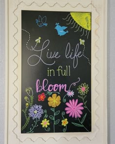 a chalkboard with flowers and butterflies on it that says live life in full bloom