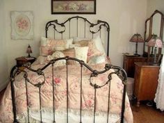 a bedroom with a bed, dresser and pictures on the wall