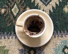 a coffee cup that has been left on the floor with some brown stuff in it