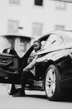 a man sitting on the back of a car