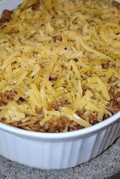 a casserole dish with cheese and ground beef in it on a counter top