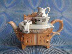 there is a tea pot and two cups on top of a table with a blue background