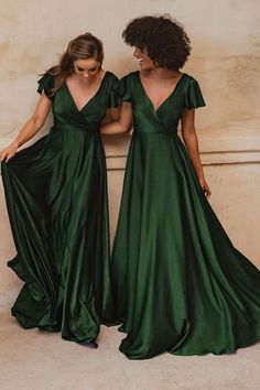 two women in green dresses standing next to each other