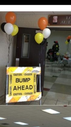 there is a sign that says bump ahead in front of some balloons on the floor