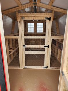 the inside of a chicken coop with doors open