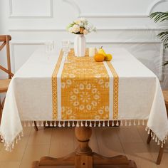 an orange and white table cloth on top of a wooden table