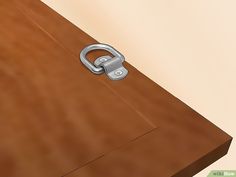 a close up of a wooden table with a metal ring on it's end