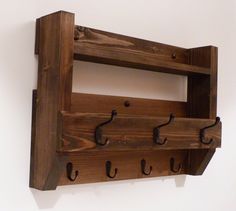 a wooden shelf with three hooks on it