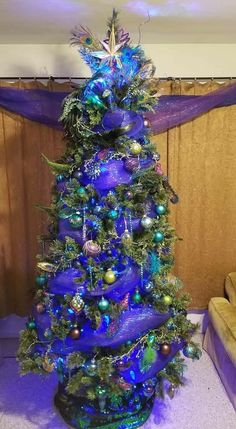 a blue christmas tree with ornaments on it