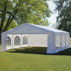 a white tent set up in the middle of a field with windows on each side