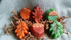 four soaps with leaves on them sitting next to each other