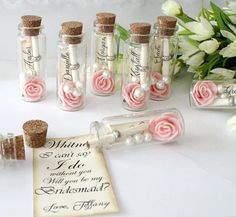 small bottles with pink roses and pearls in them