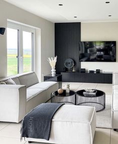 a modern living room with white furniture and black accents