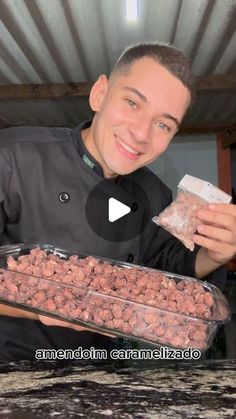 a man holding a tray of food in front of him and smiling at the camera