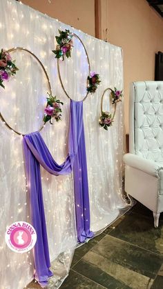 the backdrop is decorated with purple flowers and gold hoop wreaths, along with lights