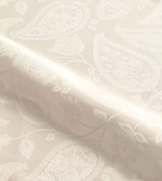 a close up view of a white wallpaper with an intricate design on the fabric